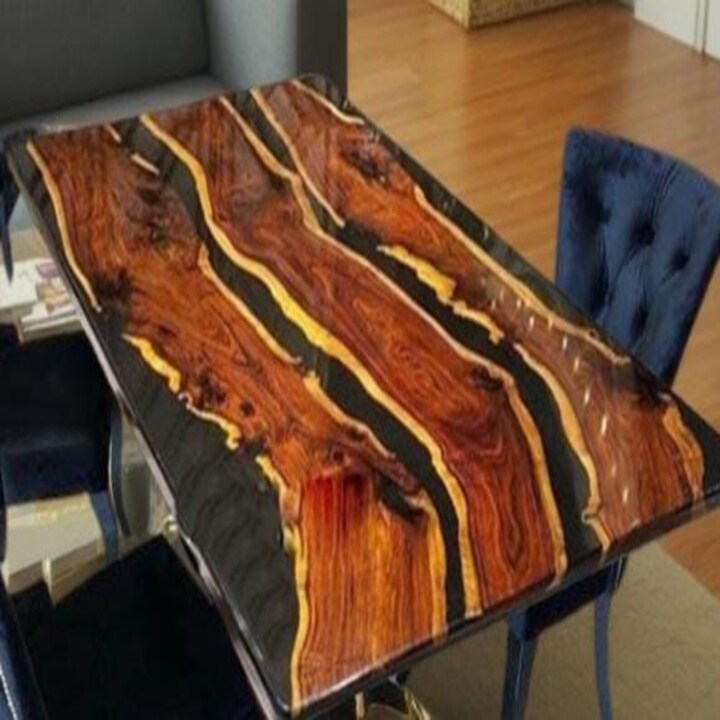 Handmade walnut black epoxy river table with live edge wood slab and glossy black resin finish for luxury interiors.